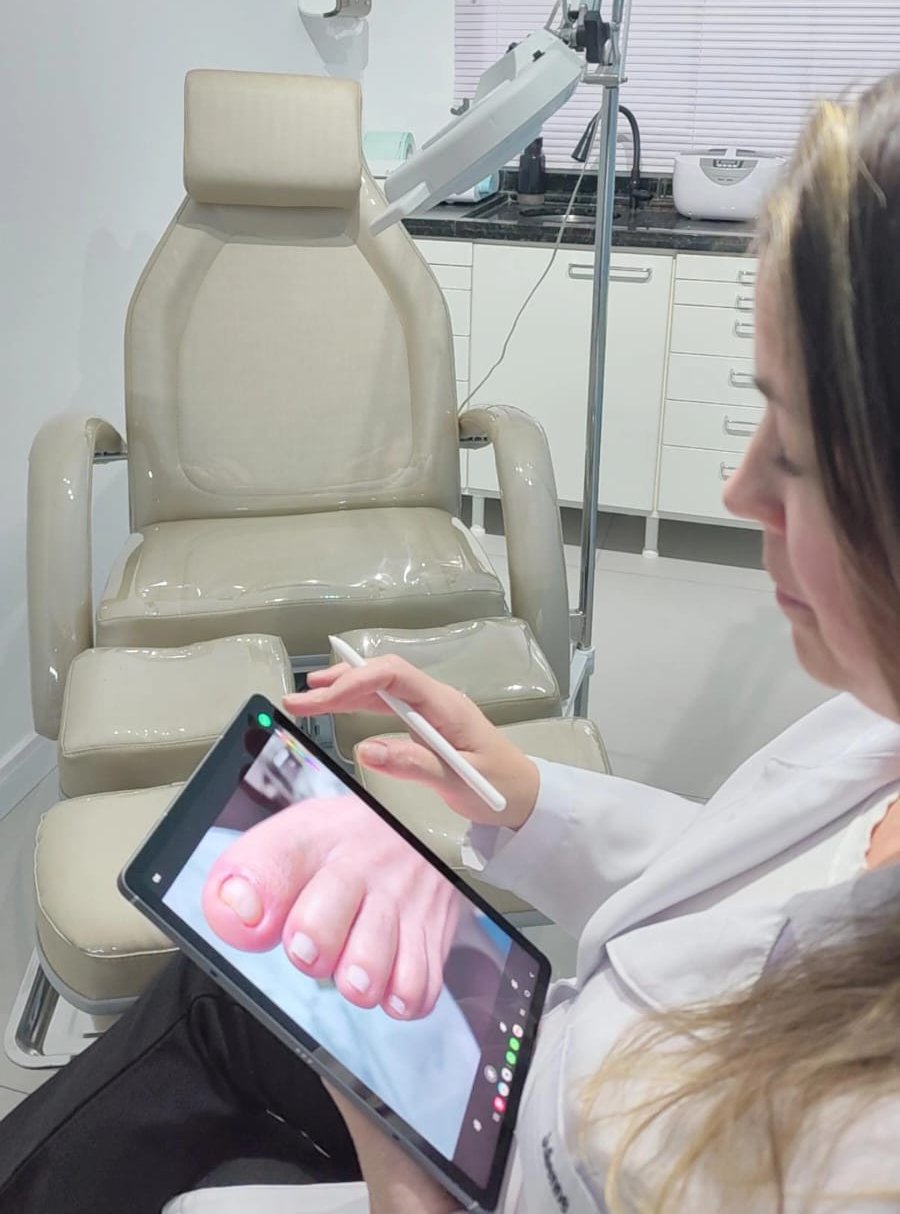 Julienne avaliando imagem do pé de paciente em tablet